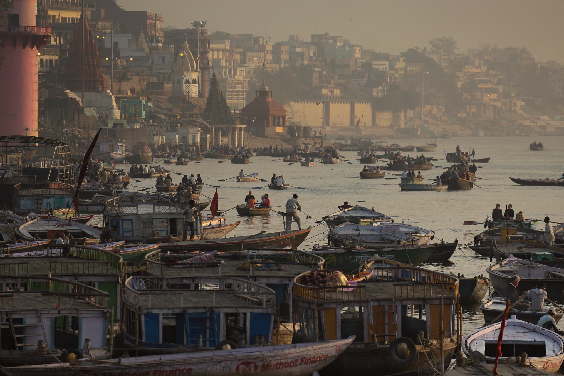 Rowing boats passing Varanasi's ghats at dawn