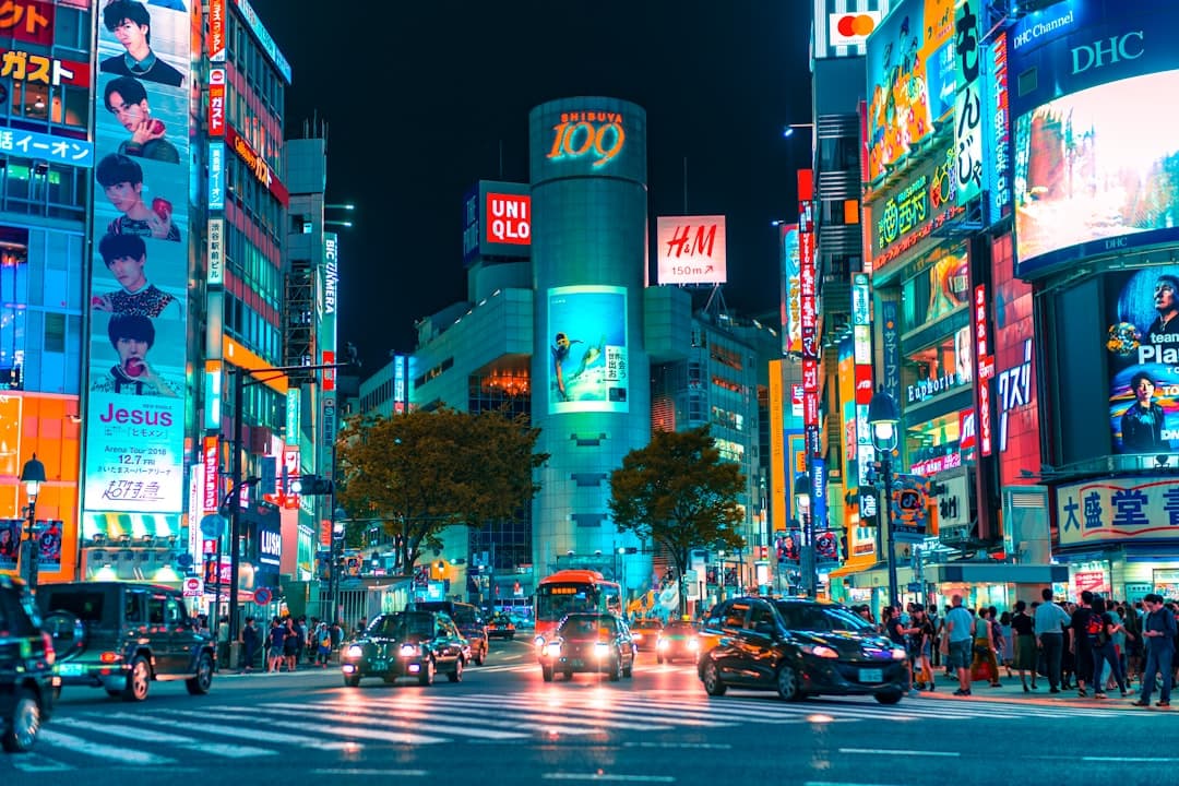 Shibuya's neon-lit streets at night, crowds crossing beneath the towers