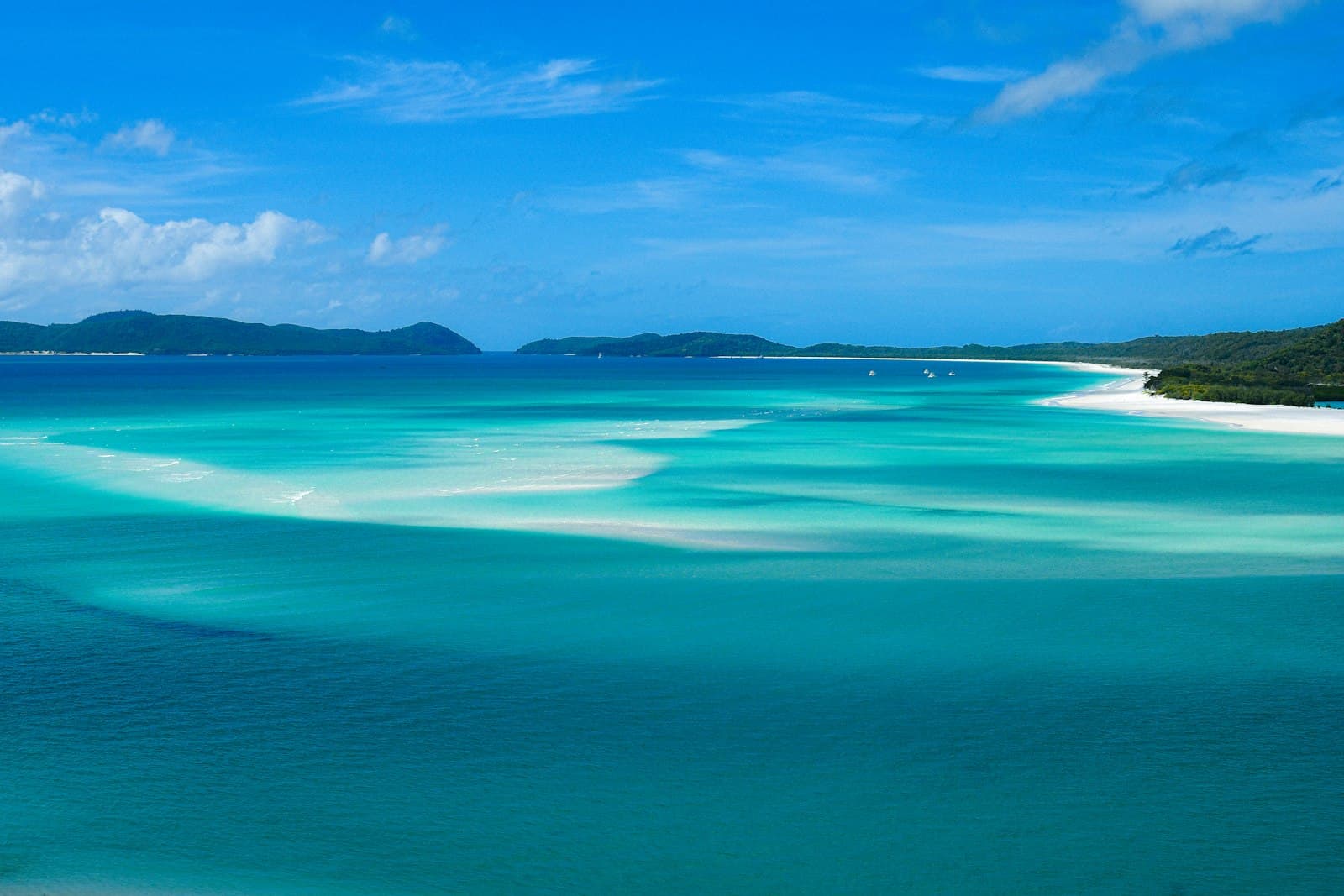 Turquoise water swirling over white sand at Whitehaven Beach in the Whitsundays