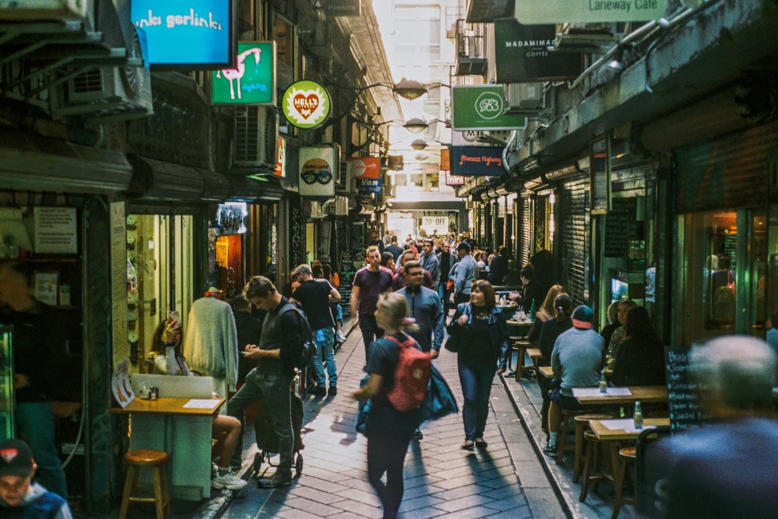 A busy Melbourne laneway lined with cafés and hanging signs