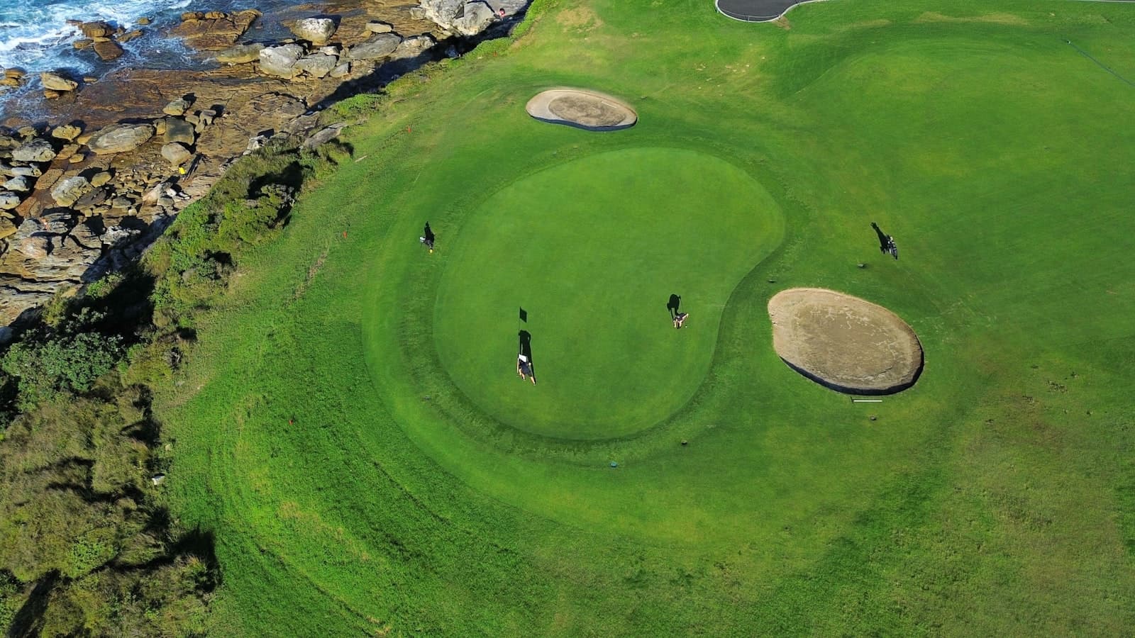A clifftop golf green beside the Pacific, seen from above