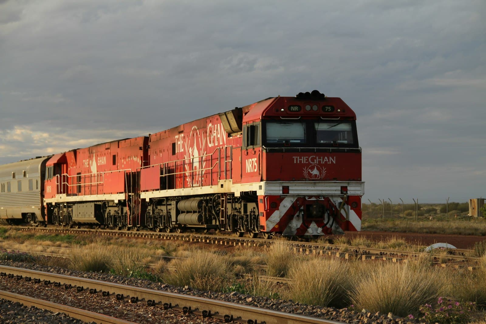 The Ghan's red locomotives crossing outback grassland