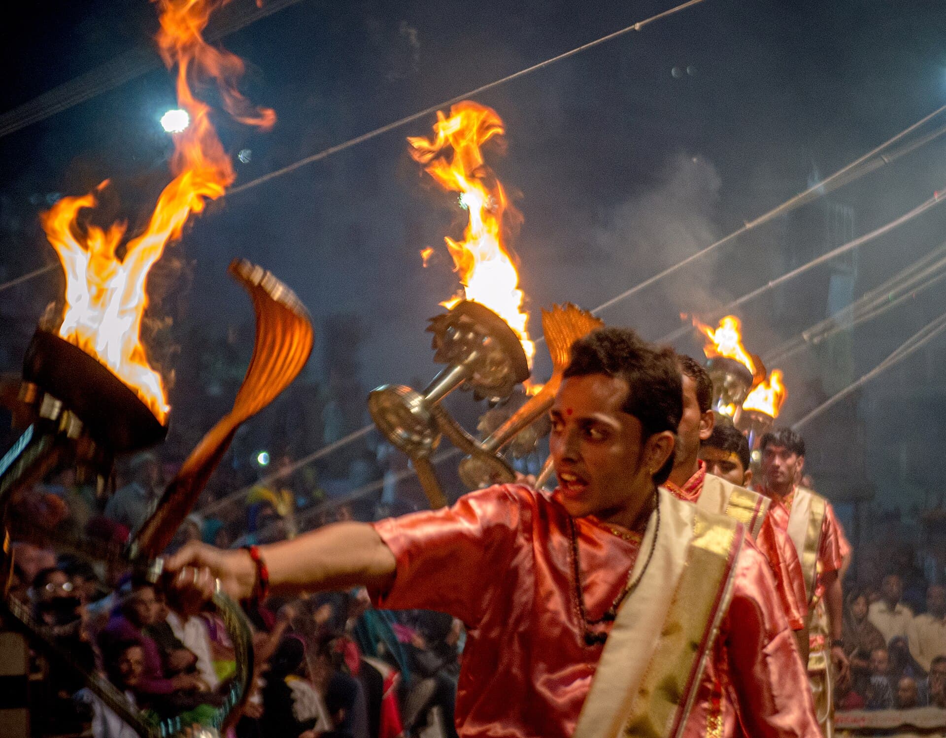 A priest swinging fire lamps at the Ganga Aarti ceremony