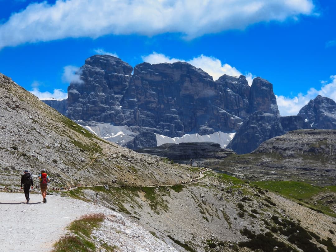 A hiker on an alpine trail beneath Dolomite spires