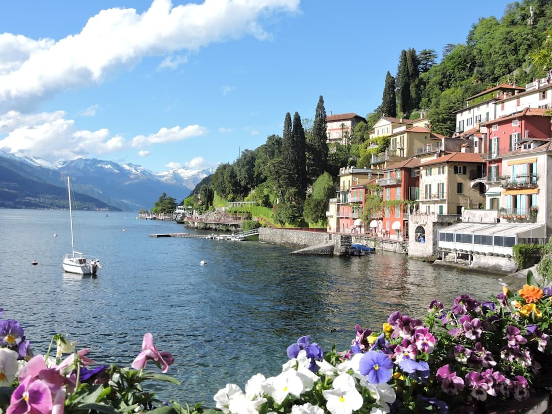 Varenna's flowered waterfront on Lake Como, snowy Alps beyond