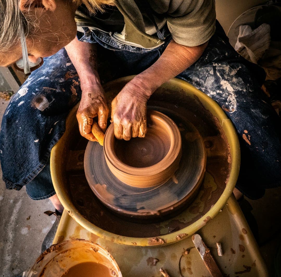 A potter shaping a vessel at the wheel