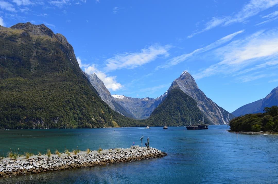Cruise boats gliding across Milford Sound beneath Mitre Peak