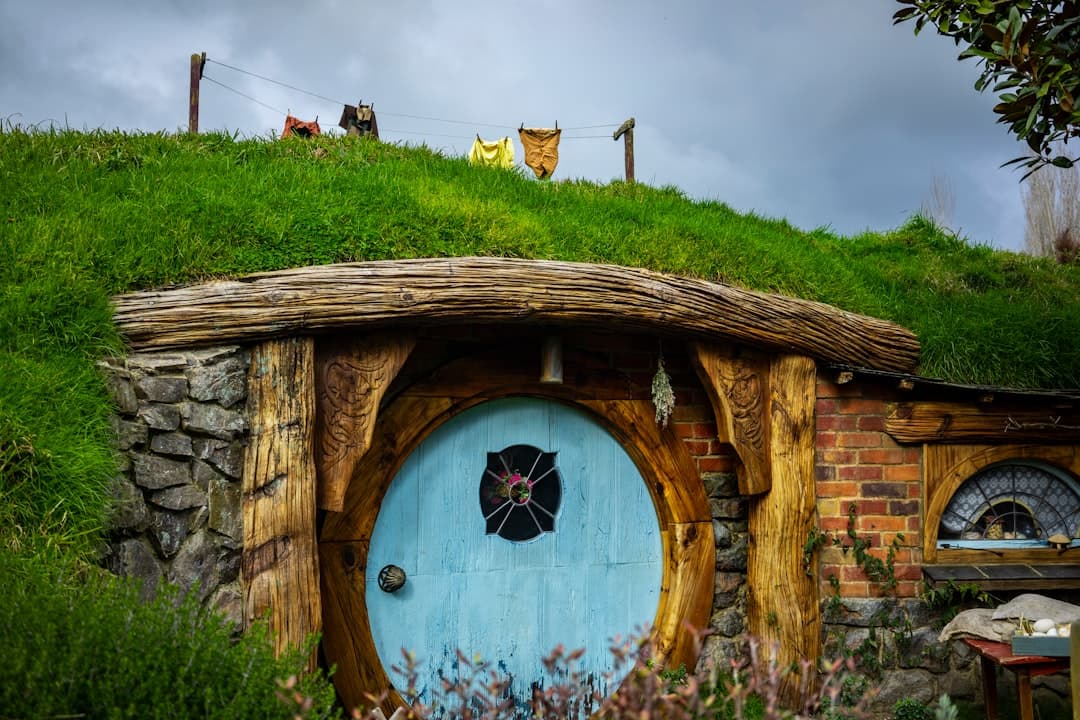 A round blue hobbit-hole door set into a grassy hillside at Hobbiton