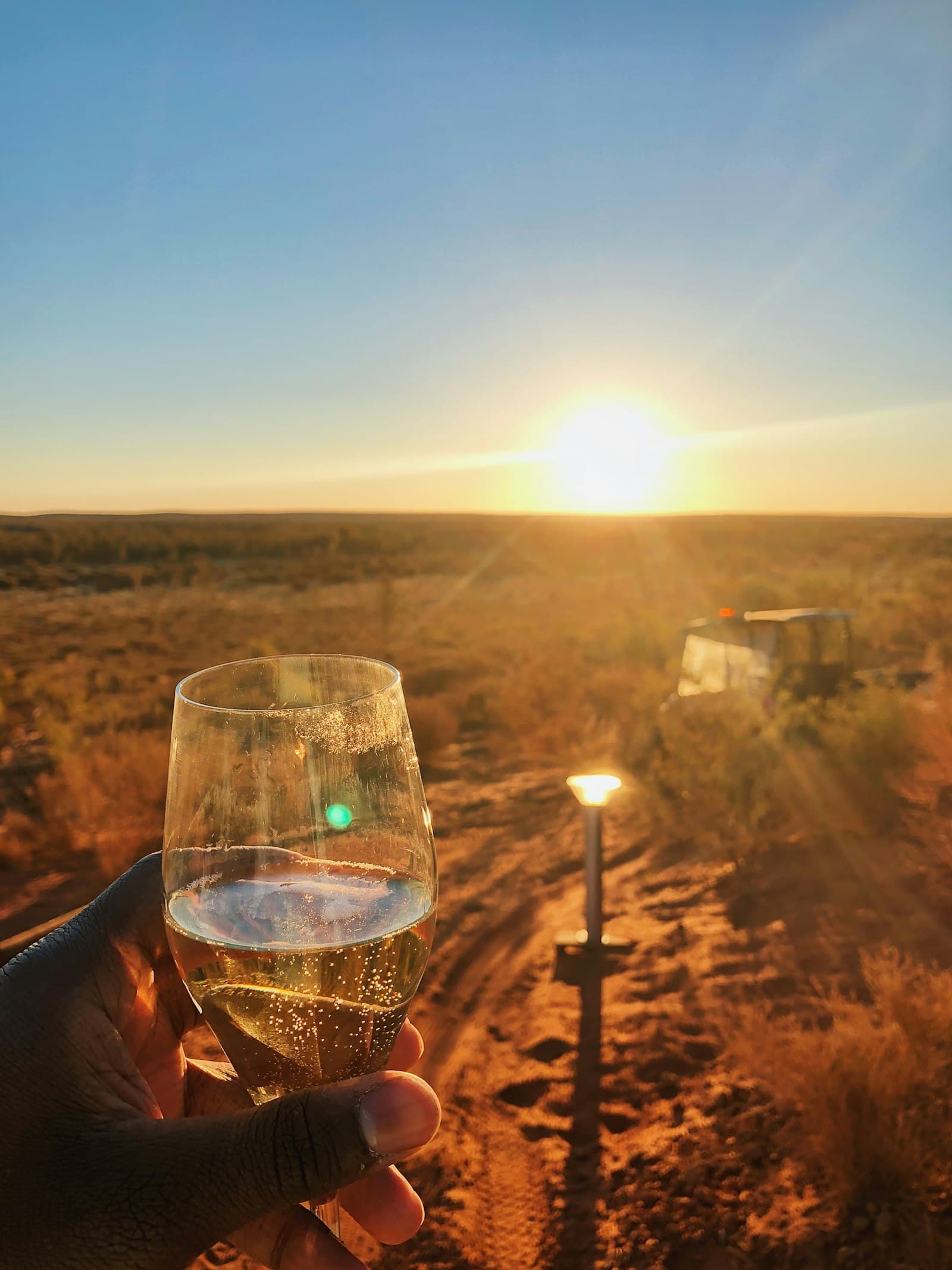 A glass raised to the sunset from a private safari drive