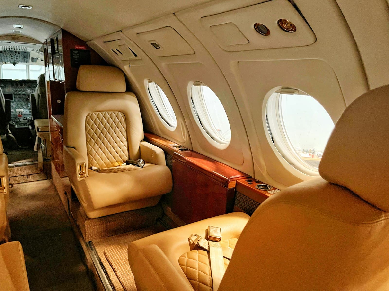 A private jet cabin in cream leather and warm wood
