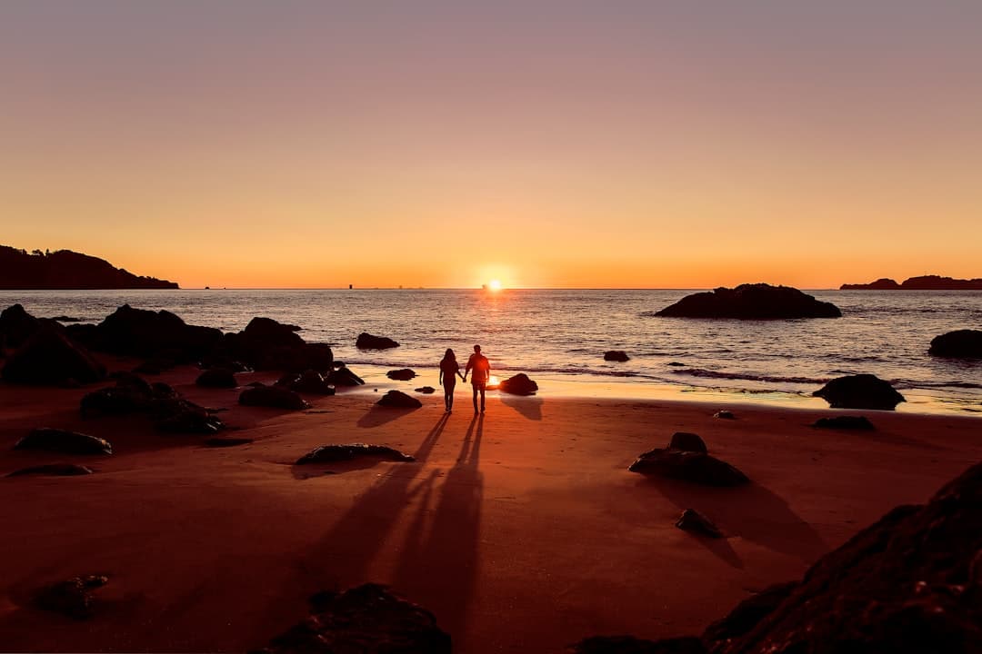 A couple watching a tropical sunset from the sand