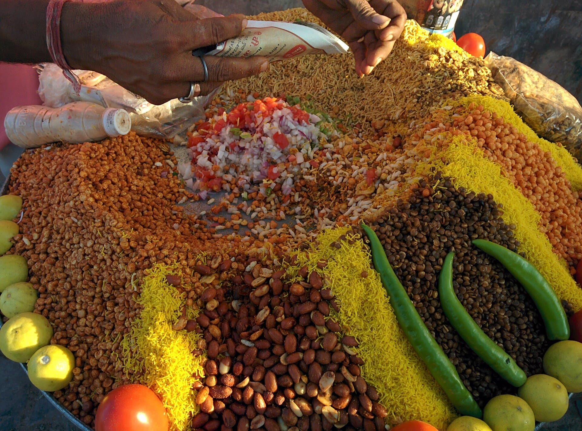 A street vendor working a loaded chaat stall